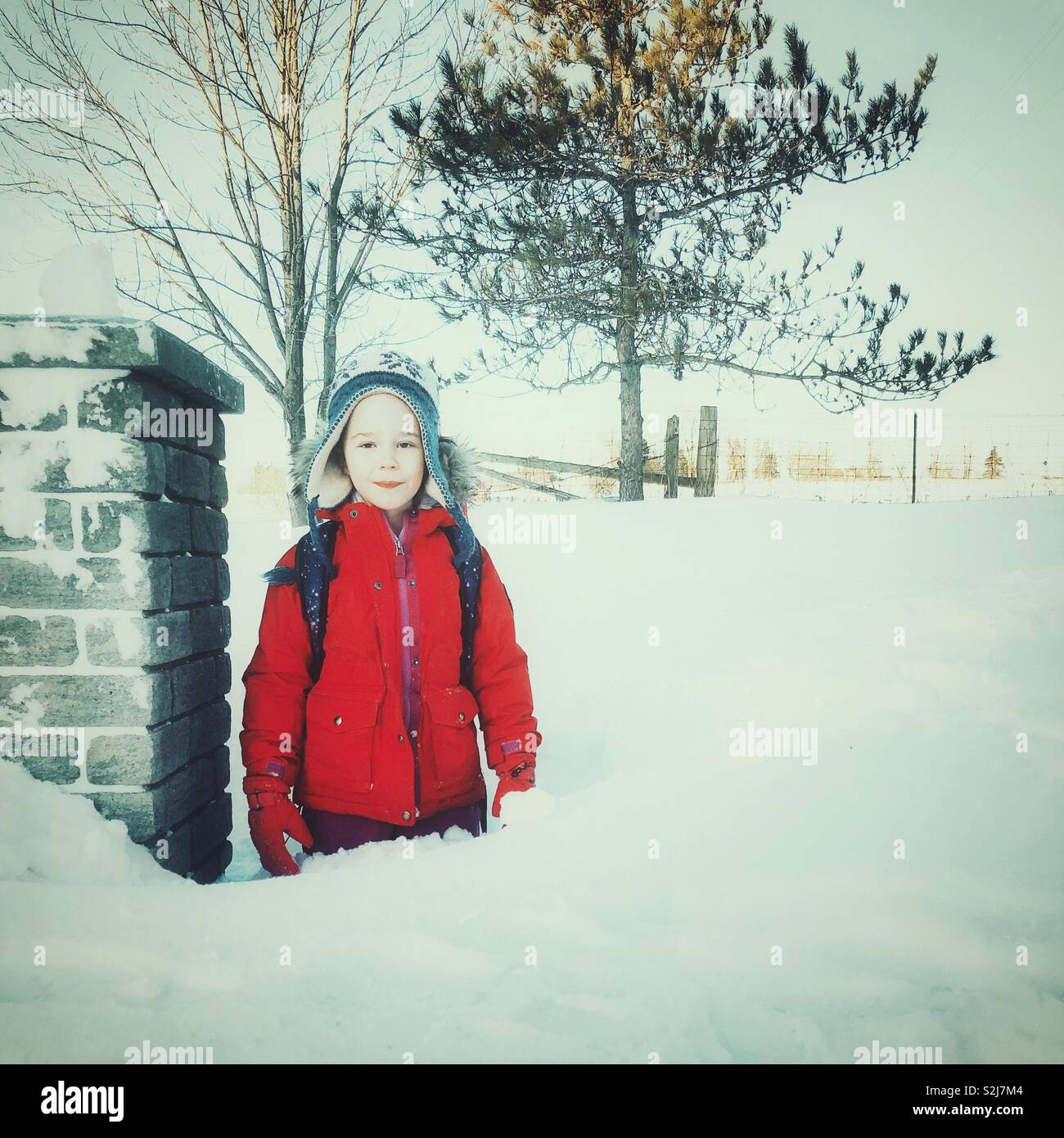 Giovane ragazza in piedi nella neve profonda Foto Stock