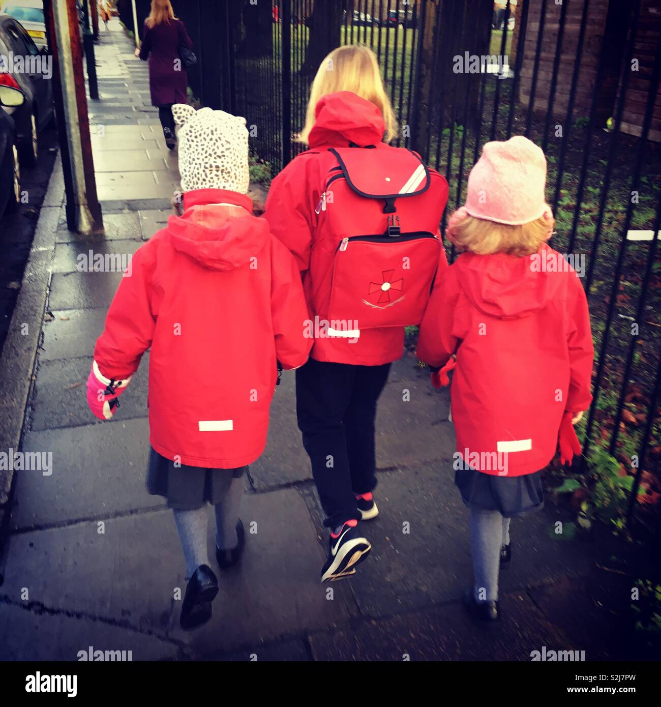 Tre giovani ragazze / 3 sorelle a piedi a scuola insieme a scuola uniforme. Regno Unito Foto Stock