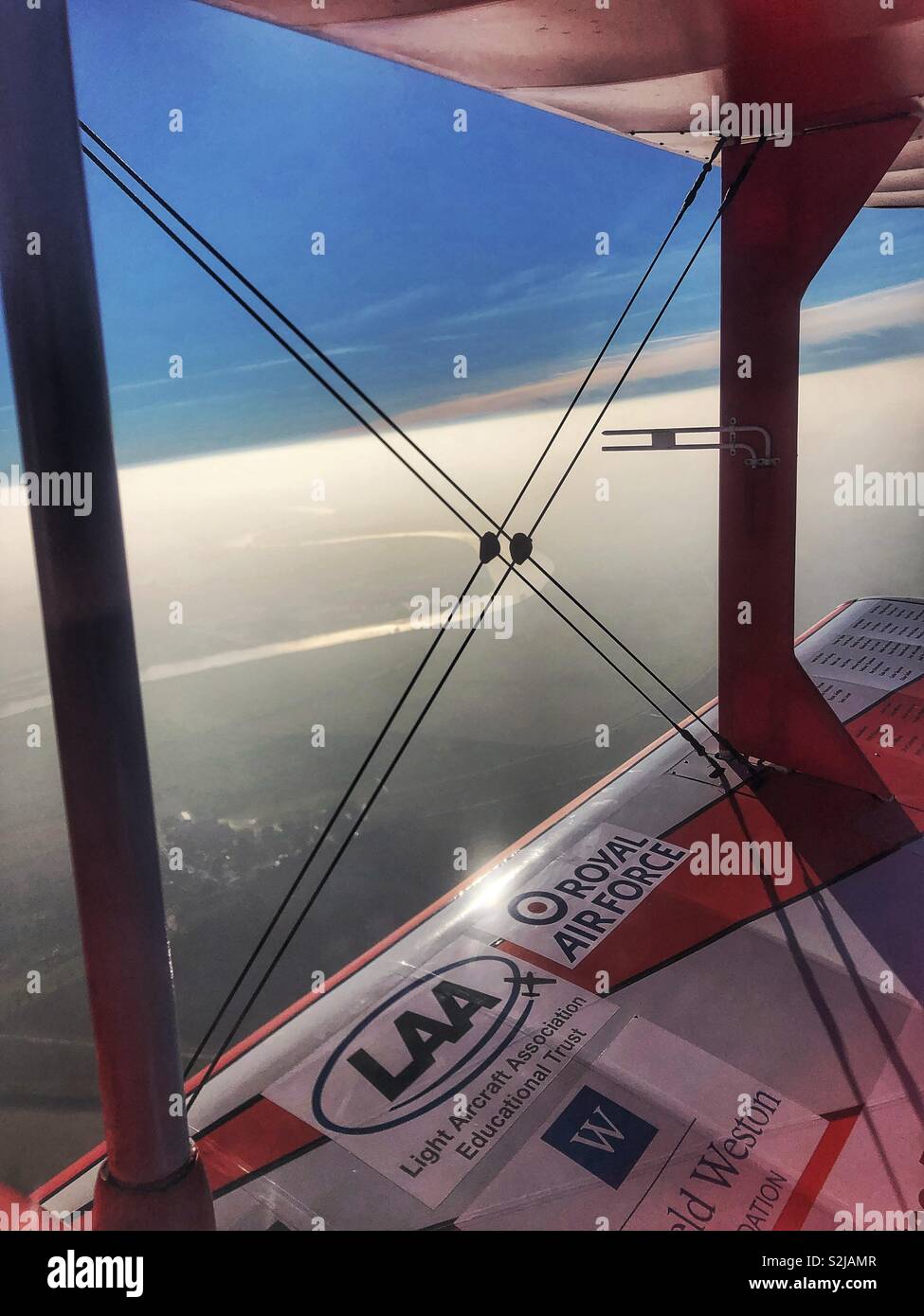 Il pilota vista da un pozzetto aperto un biplano volando sopra il fiume Trento Foto Stock