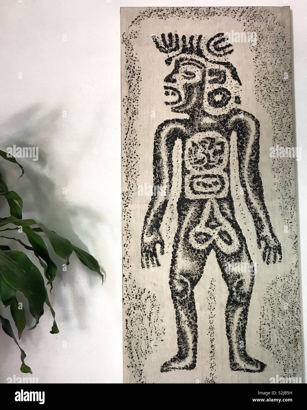 Un'opera d'arte con un Prehispanic figura decora Parador del Dominico hotel in Oaxaca, Messico - Immagine stock catturata con smartphone