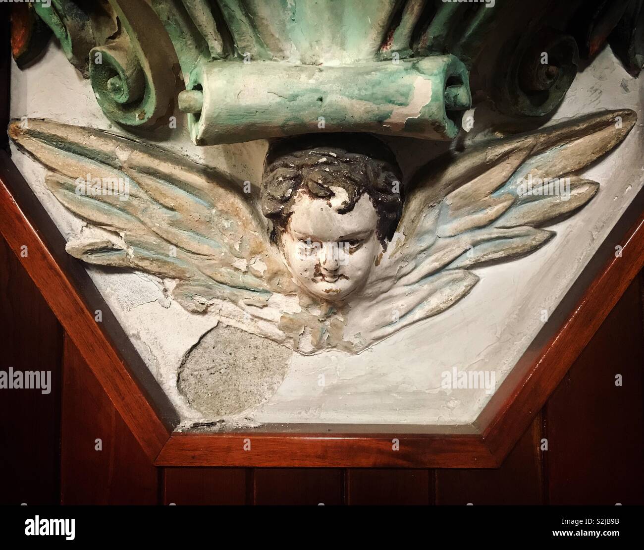 Un cherubino con una faccia del male in una chiesa di Oaxaca, Messico - Immagine stock catturata con smartphone