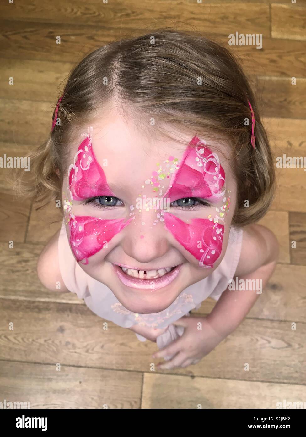 Carino quattro anno vecchia ragazza con il suo volto dipinto con face painting in stile a farfalla. Foto Stock