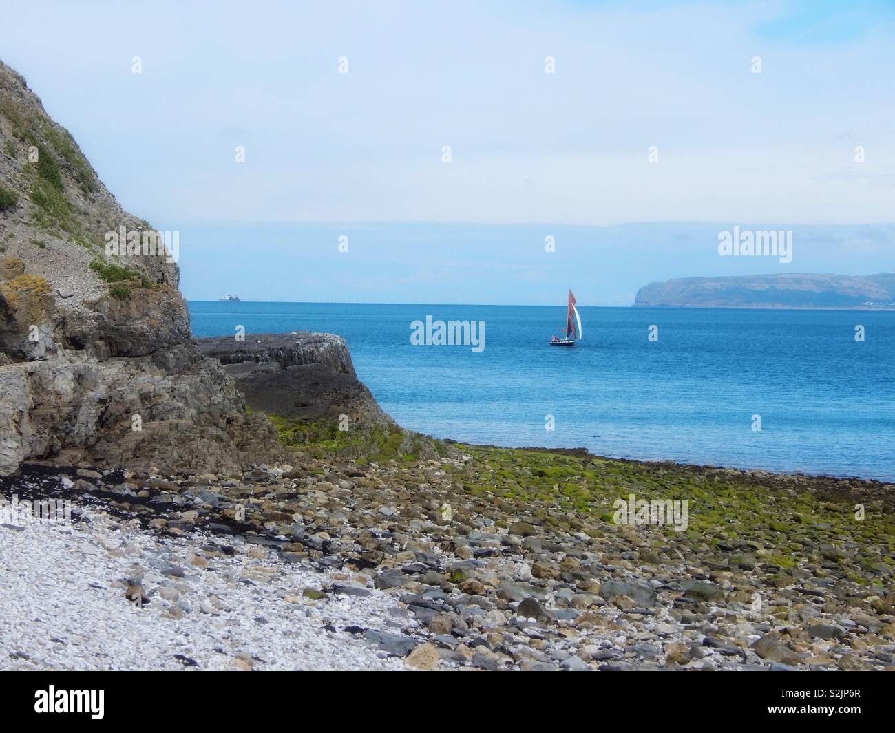 Vista dalla costa di Anglesey linea tra Beaumaris e punto di Penmon nel Galles del Nord il 23 giugno 2017. Foto Stock