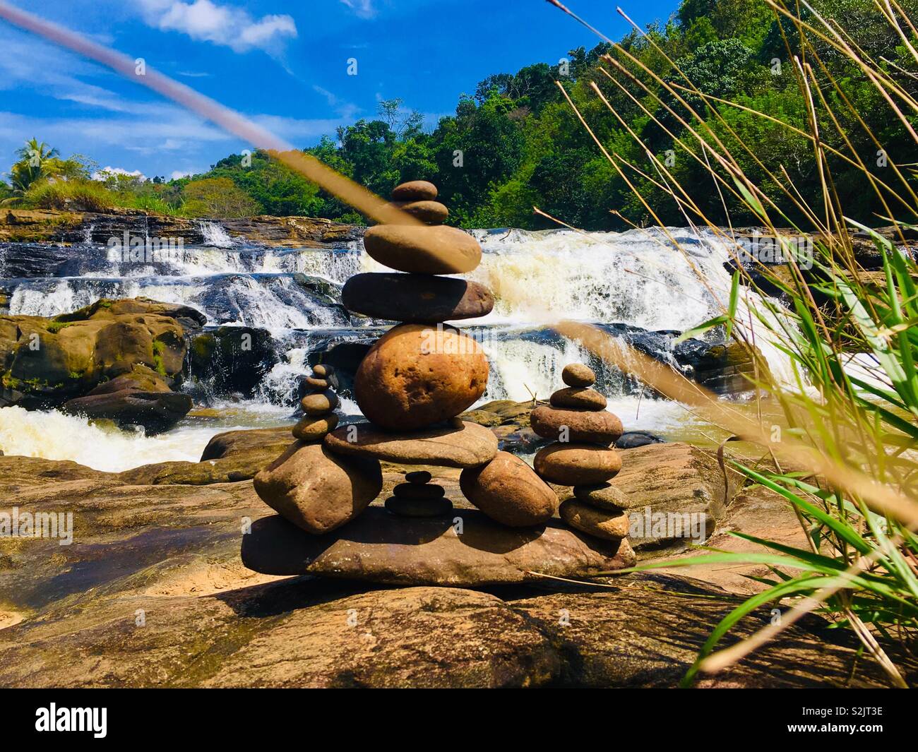 Pietre equilibrata vicino alla magnifica cascata. Meditazione per molto trafficata vita. Foto Stock