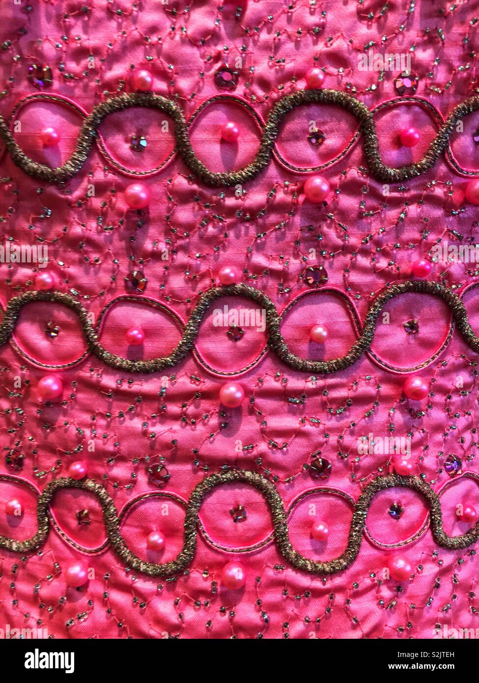 Fortemente ricamato rosa caldo formale di materiale di usura con paillettes, perle, glitter e ricami. Foto Stock