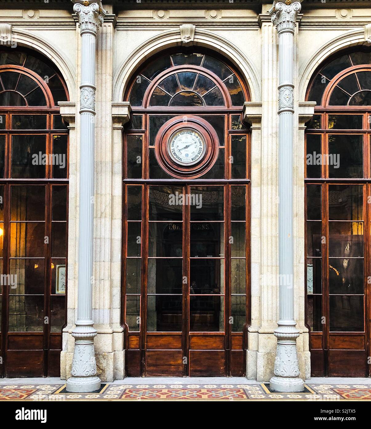 Alti, neoclassico, porte vetrate con costruito nel barometro sopra pavimento piastrellato, all'interno della borsa Bolsa Palace, a Infante D Henrique Sq, Porto, Portogallo Foto Stock