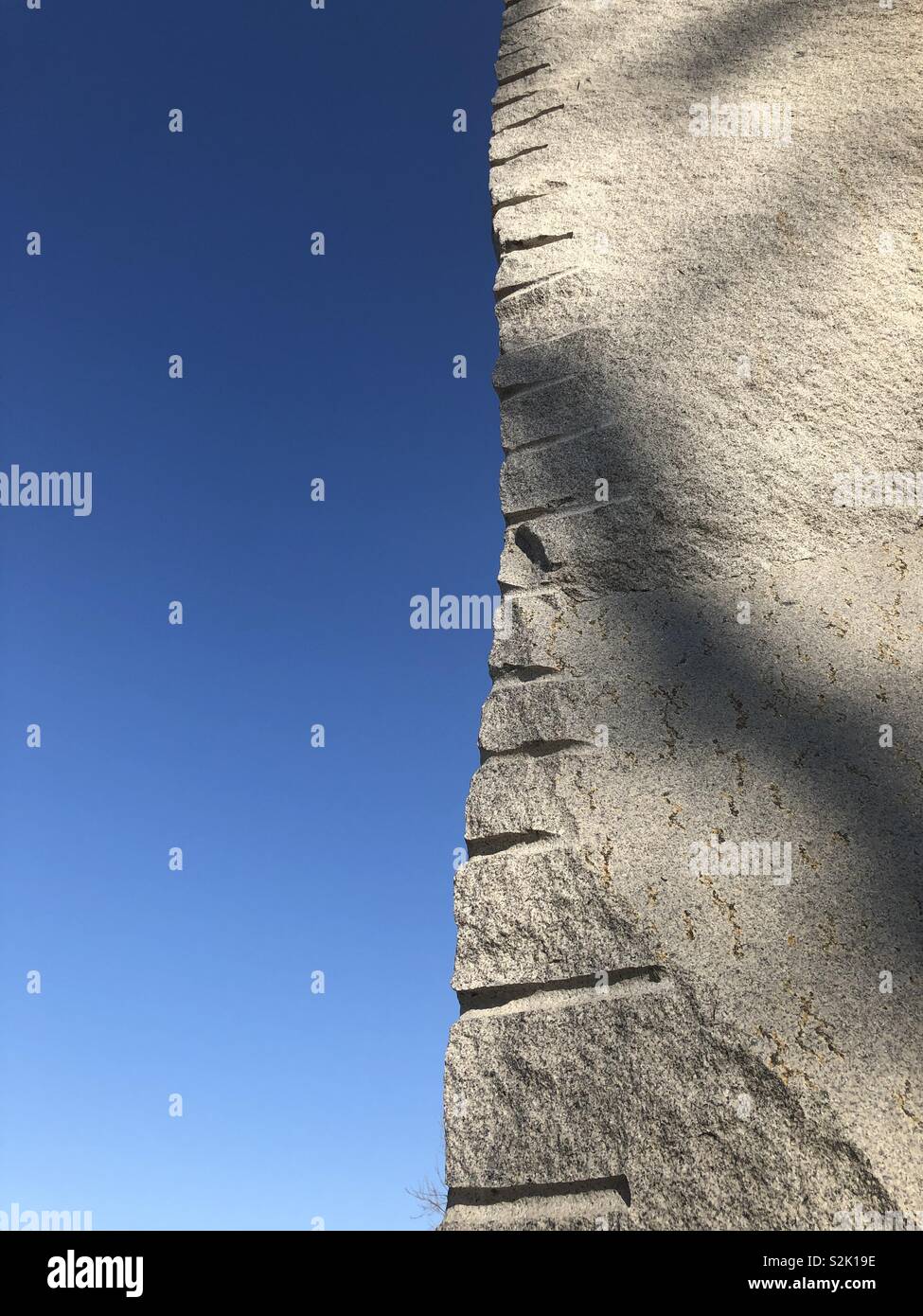 Bordo verticale di un pilastro di pietra che mostra i contrassegni contro un cielo blu, a Pechino. Foto Stock