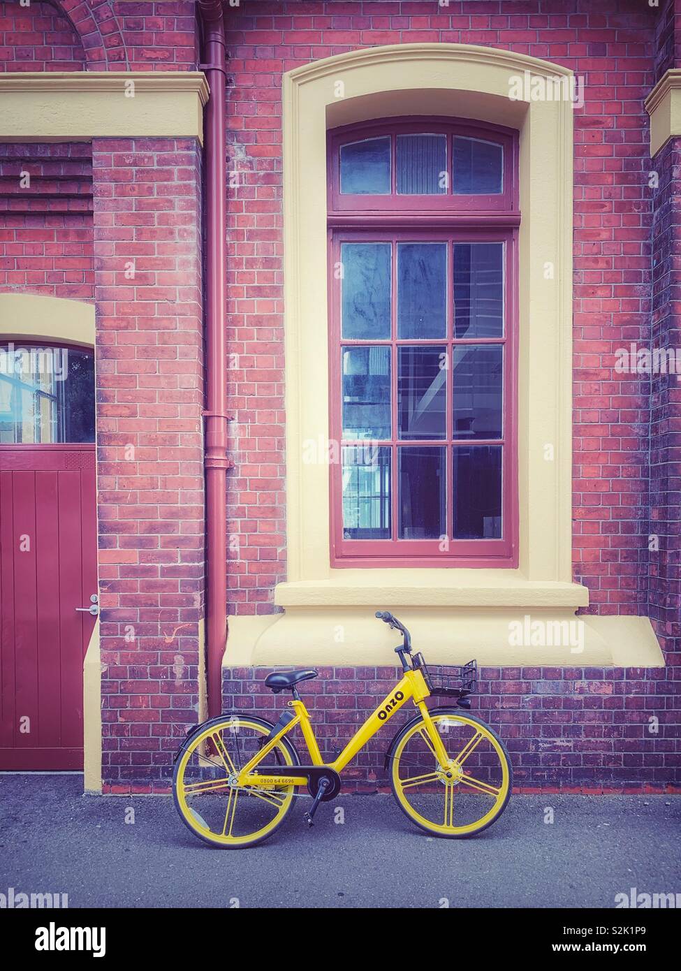 Una moto gialla su un muro di mattoni vicino a Wellington il waterfront Foto Stock