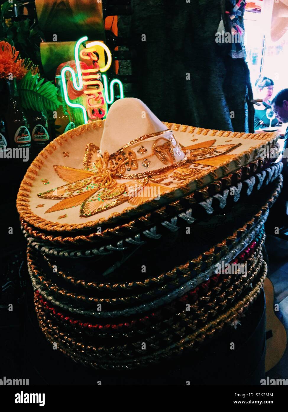 Pila di sombreros messicani in un ristorante messicano con neon tequila segno Foto Stock