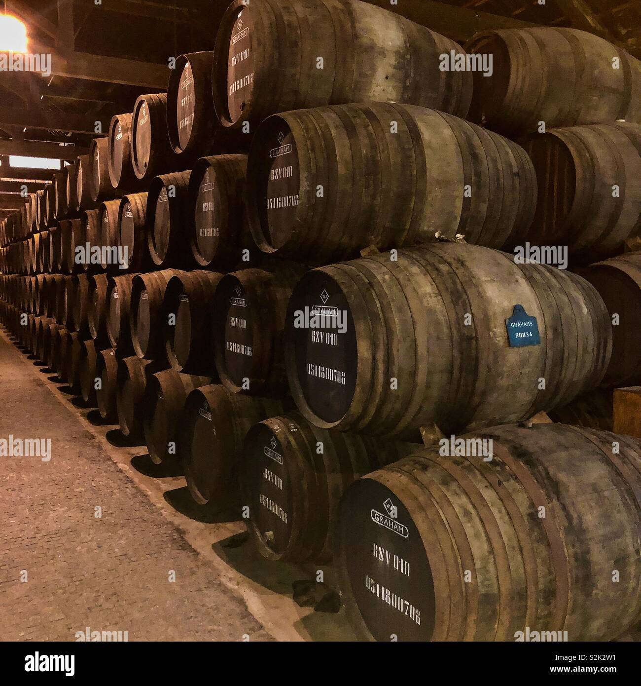 Una corsia di una pila di barili di maturazione porta in magazzino cantina di Graham in Porto, Portogallo Foto Stock