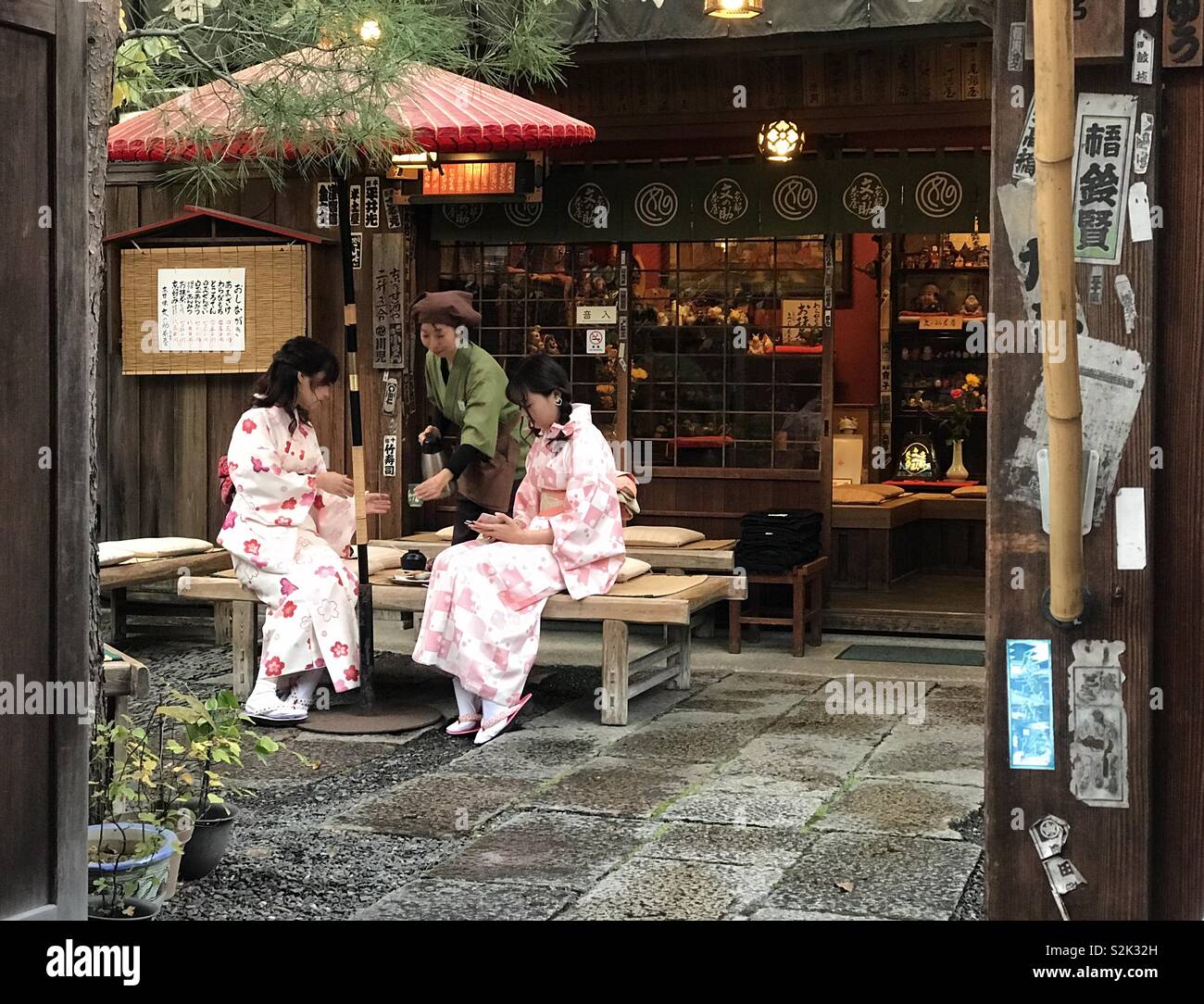 Due donne in kimono avente una conversazione su di tè in una locanda in Gion, Higashiyama, Kyoto, Giappone Foto Stock