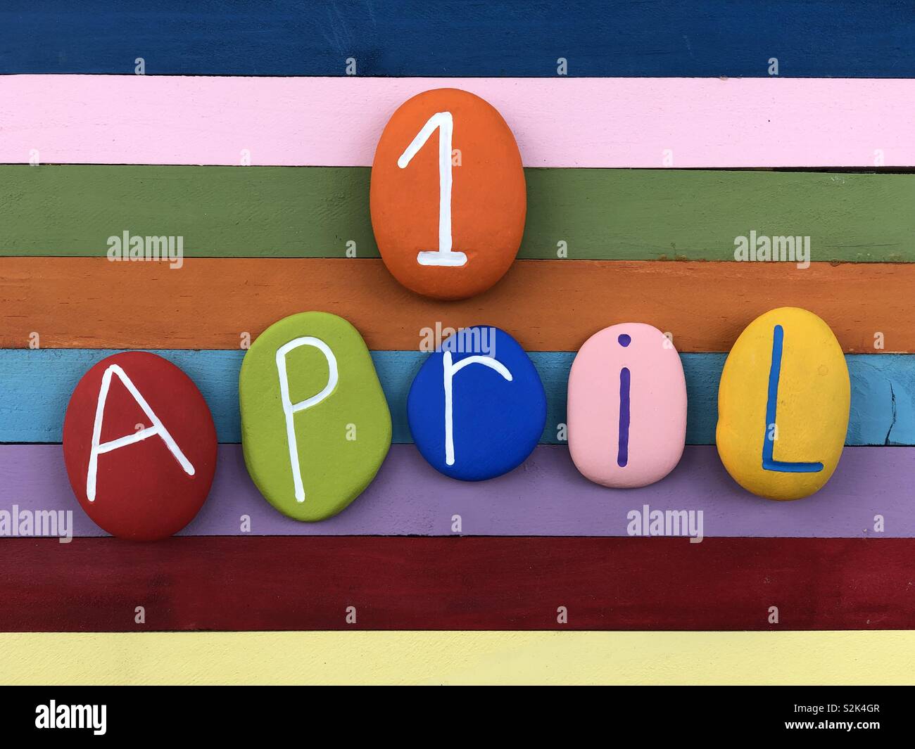 1 aprile, data di calendario con pietre colorate su multi colorata scheda di legno - Immagine stock catturata con smartphone