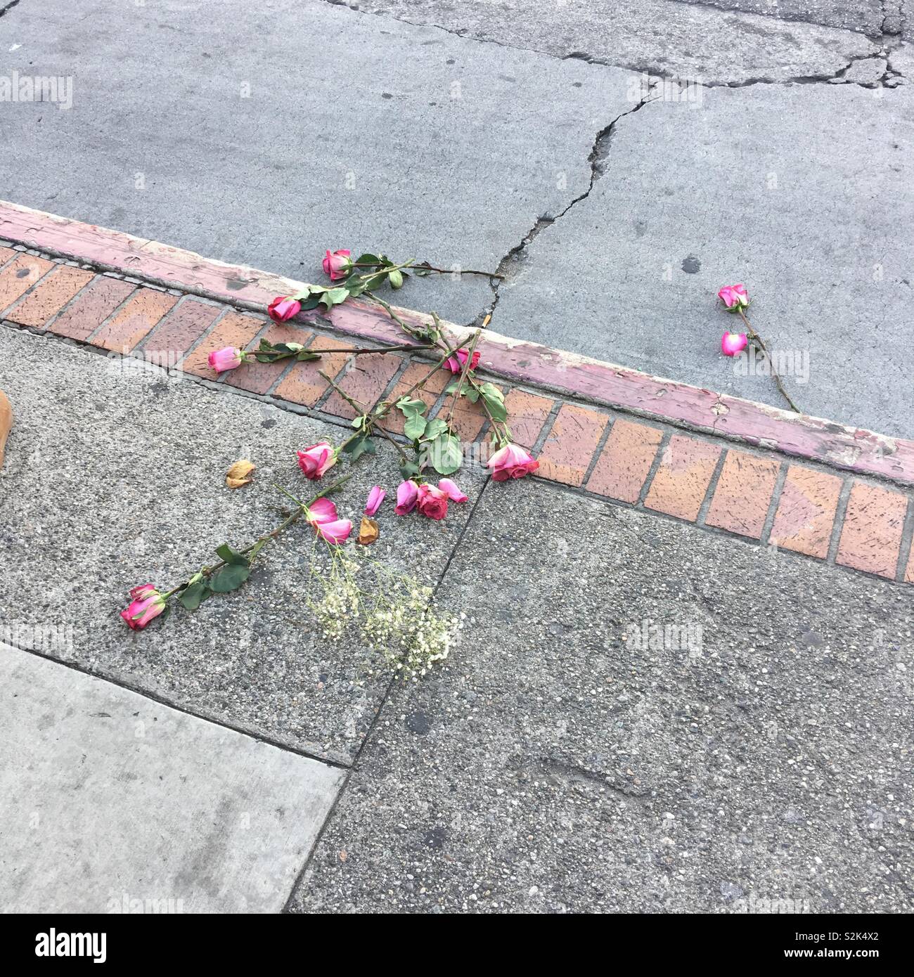 Mazzo di rose gettato a lato di una strada Foto Stock