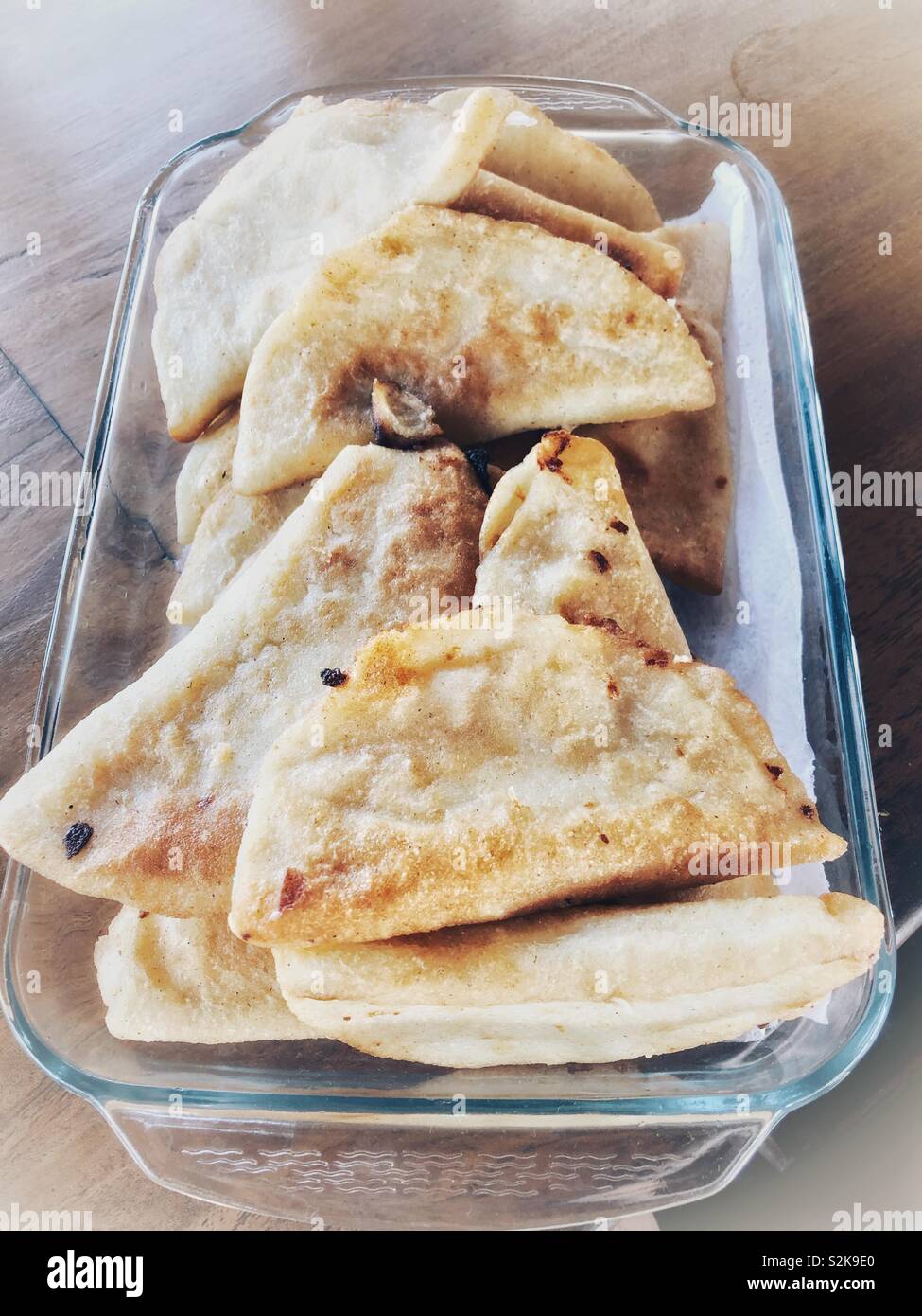 Un piatto di vetro riempito con appena cotti e fritti empanadas. - Immagine stock catturata con smartphone Un piatto di vetro riempito con appena cotti e fritti empanadas. - Immagine stock catturata con smartphone