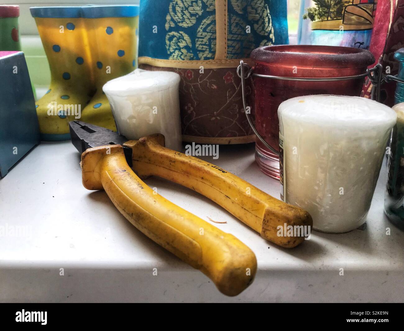 Una coppia di pinze aggiungere al disordine sulla cucina davanzale. Foto Stock