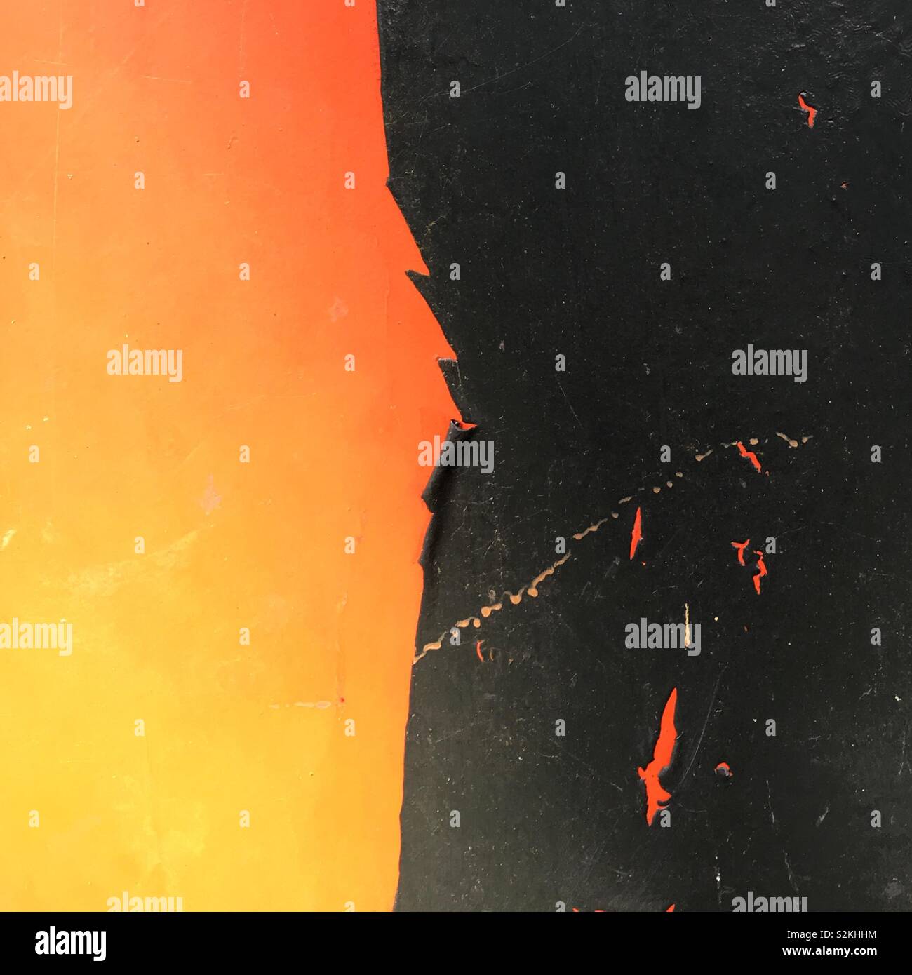 Peeling vernice nera sulla fiamma sfondo arancione Foto Stock