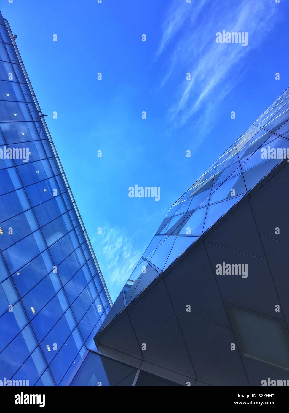 Gli edifici che riflette il cielo blu e nuvole in Spiningfields area di Manchester Foto Stock