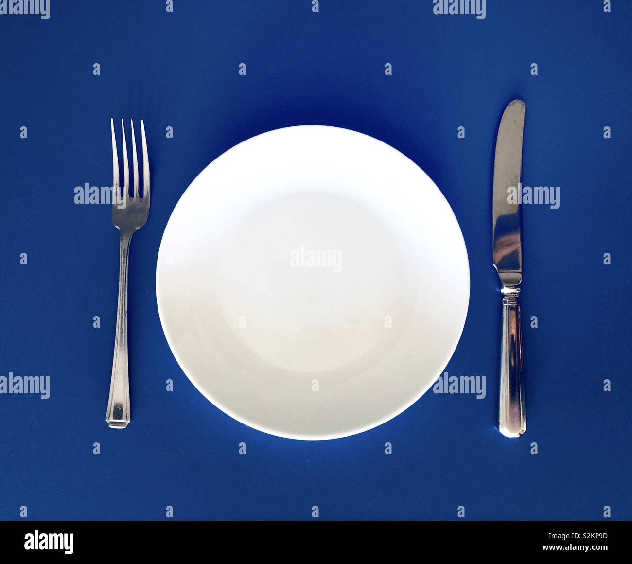 Piastra e coltello forcella sullo sfondo blu - Immagine stock catturata con smartphone