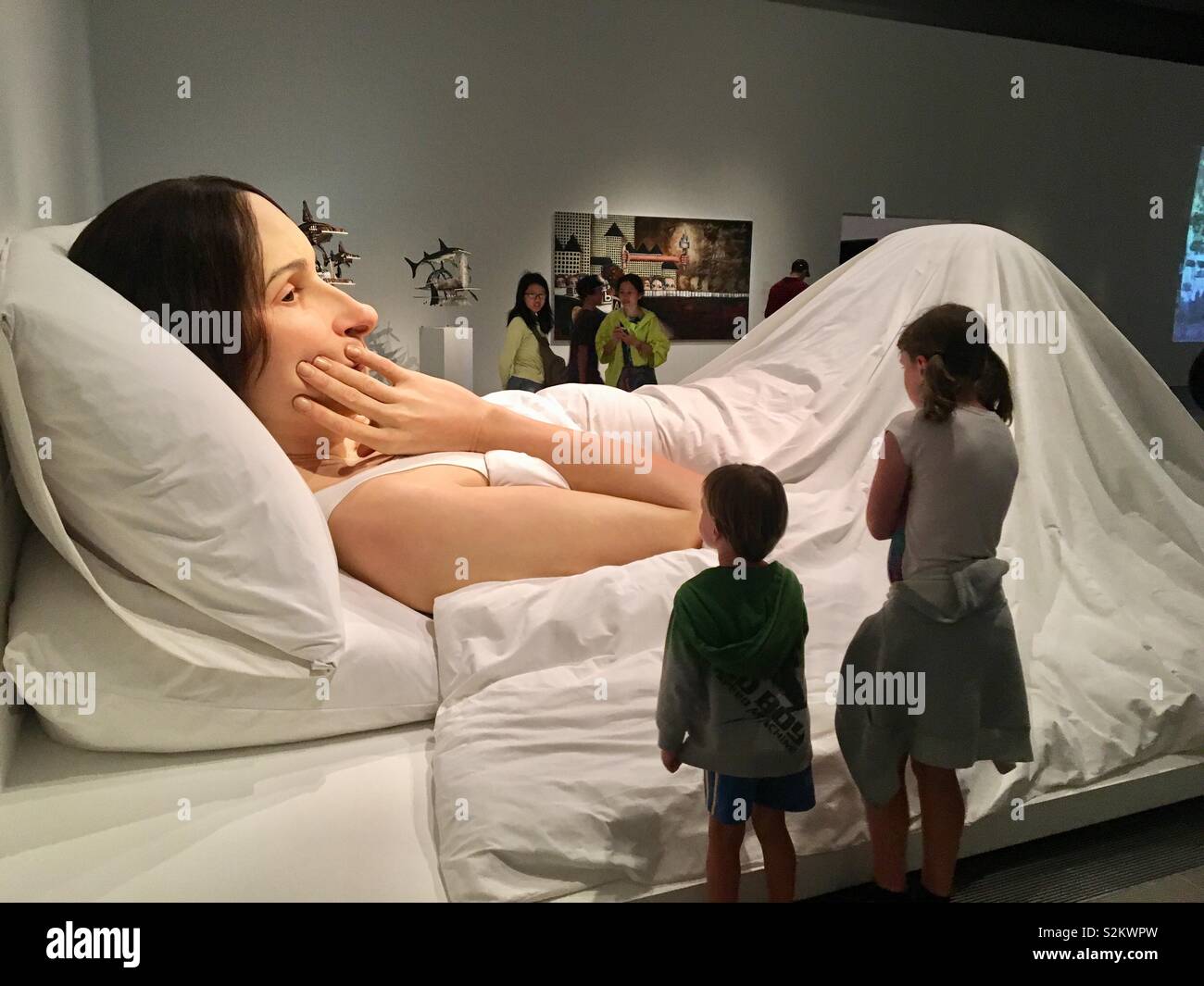 Galleria d'arte installazione di scultura dell'artista Ron Mueck con bambini in cerca su Foto Stock