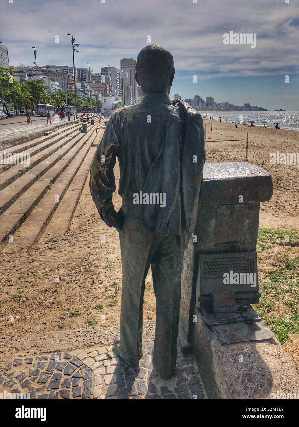 Una statua di bronzo di un uomo dal retro che si affaccia verso la spiaggia di Ipanema a Rio de Janeiro in Brasile. - Immagine stock catturata con smartphone Una statua di bronzo di un uomo dal retro che si affaccia verso la spiaggia di Ipanema a Rio de Janeiro in Brasile. - Immagine stock catturata con smartphone