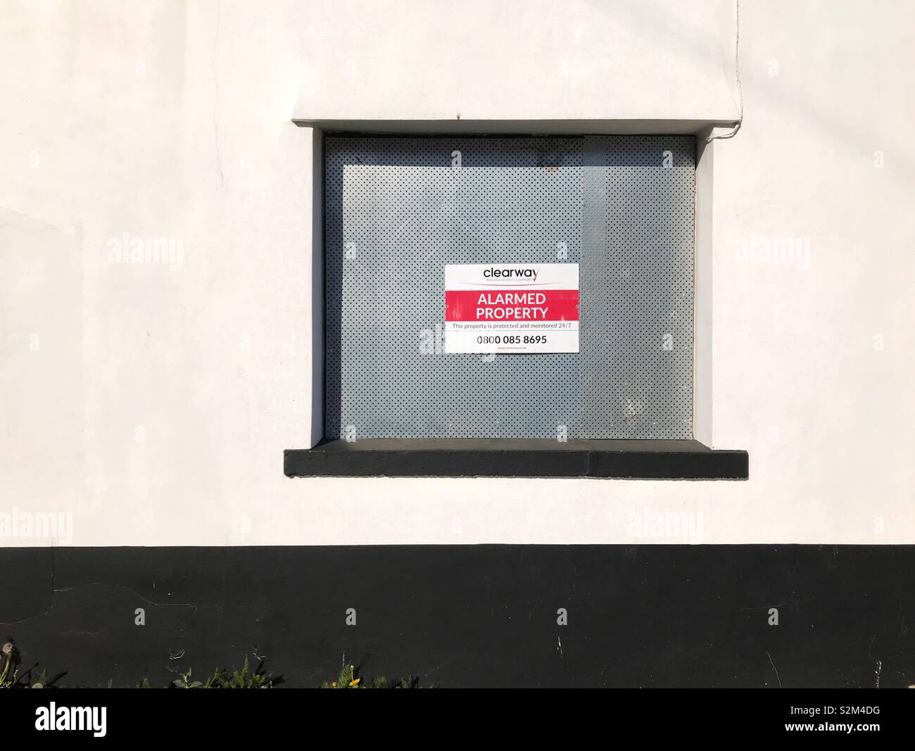 Intavolato con la finestra Avviso di protezione su una casa pubblica che ha chiuso Foto Stock