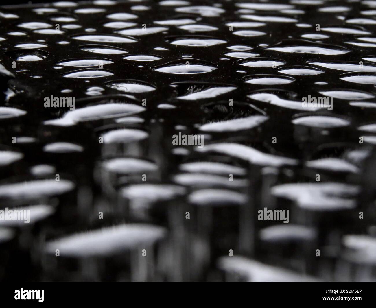 Le goccioline di acqua su un tavolo di vetro Foto Stock