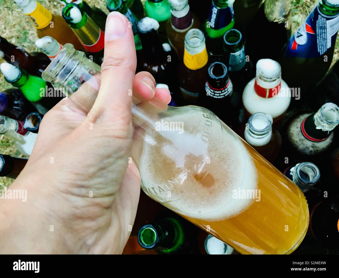 Persona in possesso di una bottiglia di birra Foto Stock