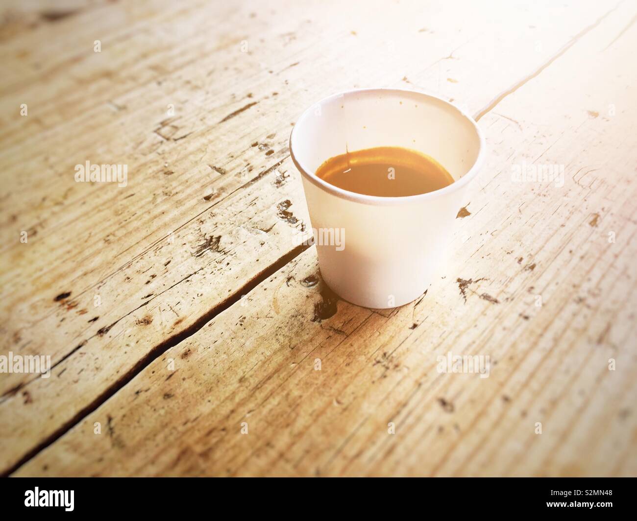 Monouso di carta riciclata con tazza di caffè su una tavola di legno in una giornata di sole Foto Stock