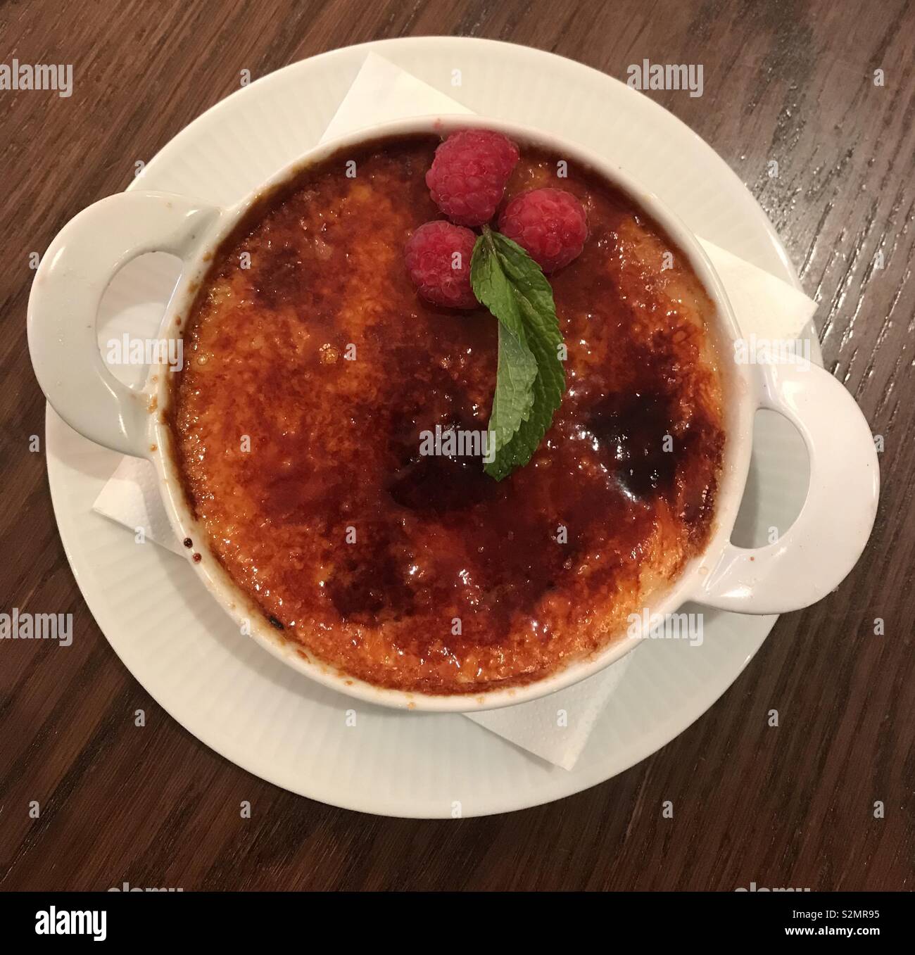 Il cioccolato bianco e crema di lamponi brûlée alla Côte Brasserie, Cardiff Bay. - Immagine stock catturata con smartphone