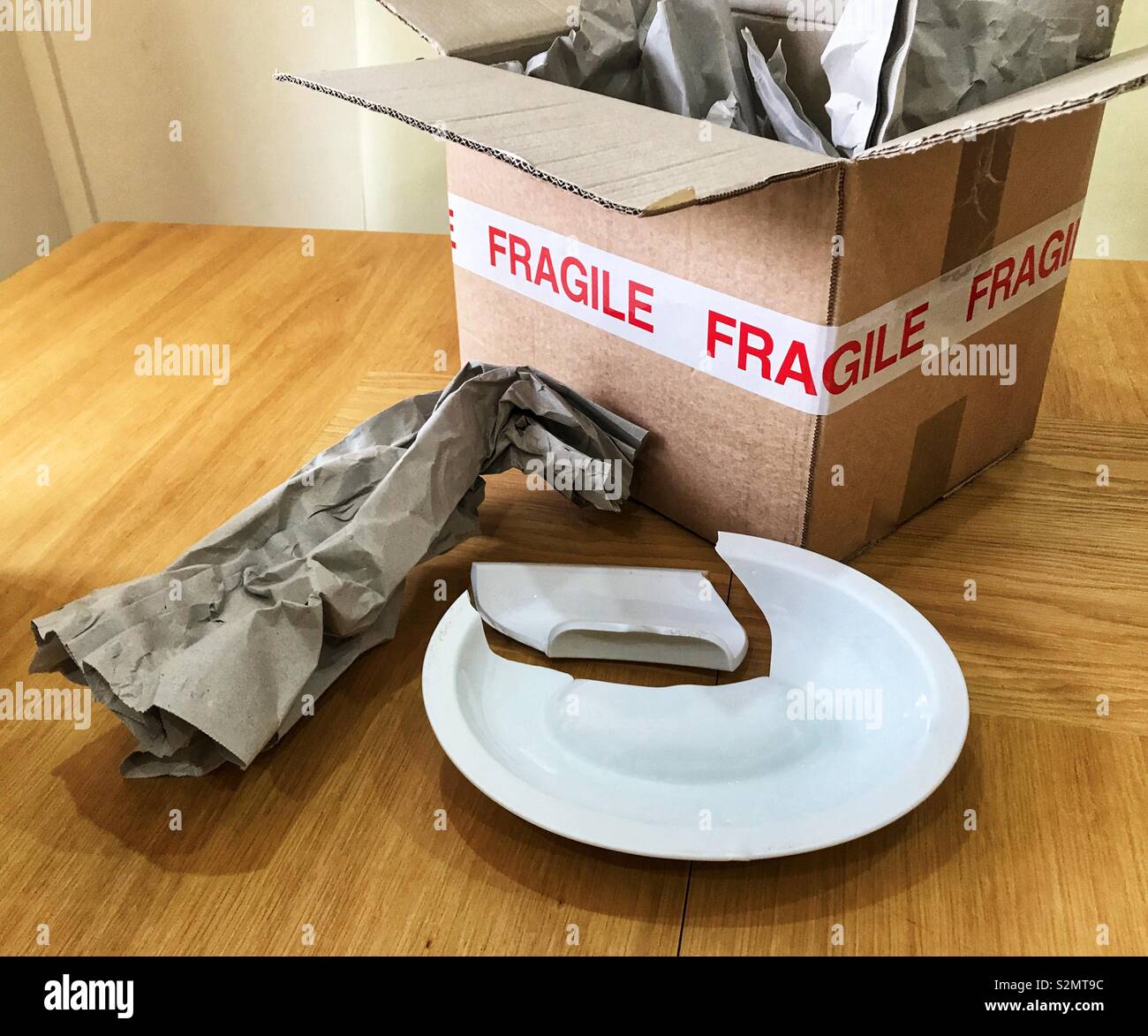 Pacco contrassegnato "fragili" con imballaggio e rotture di pezzo di cina - Immagine stock catturata con smartphone