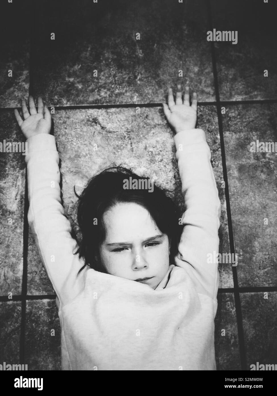 Arrabbiato giovane ragazza posa sul pavimento con le braccia in alto Foto Stock