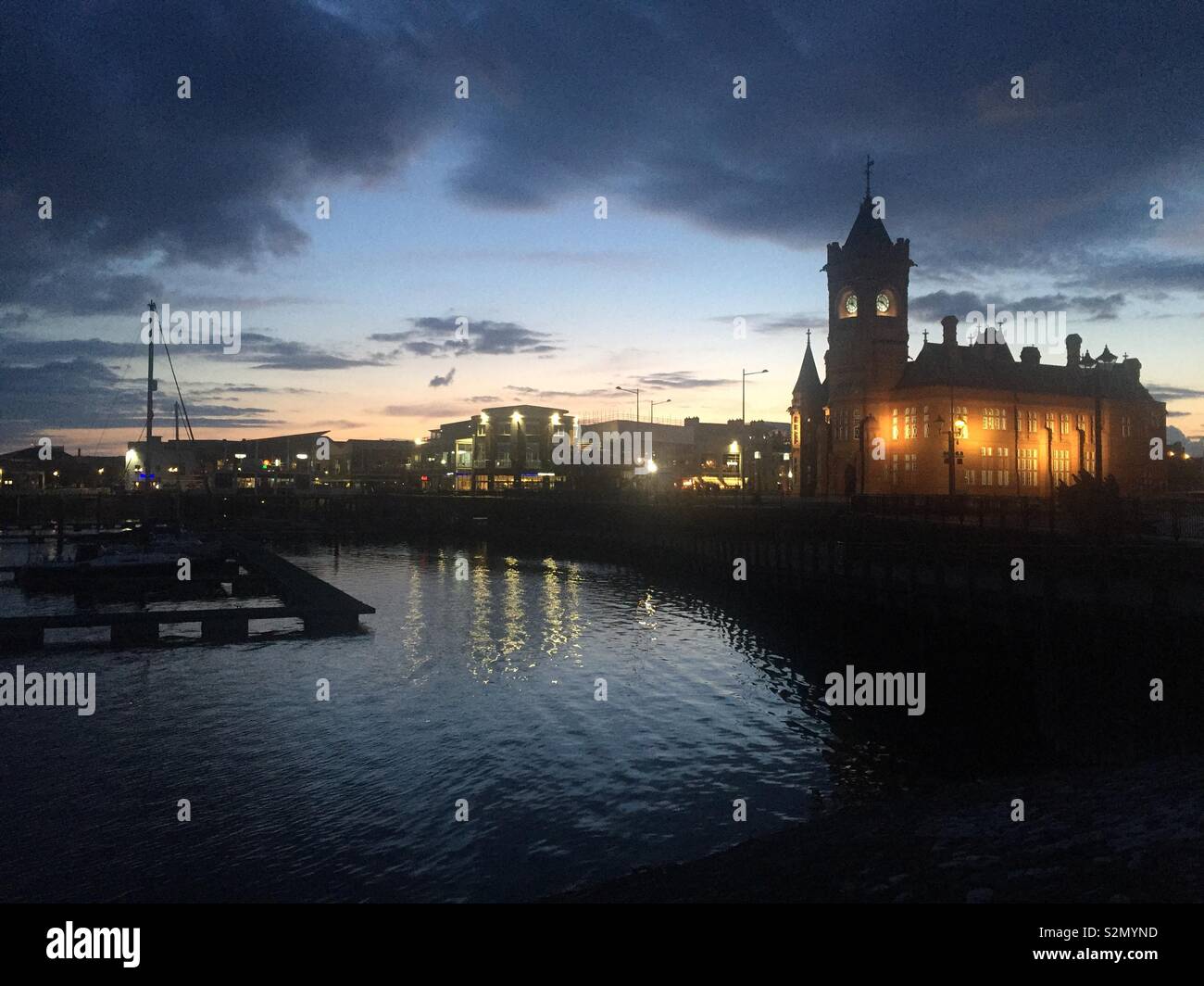 La Baia di Cardiff, compreso il Mermaid Quay e l'Edificio Pierhead, al tramonto su un inizio di maggio la sera. Foto Stock