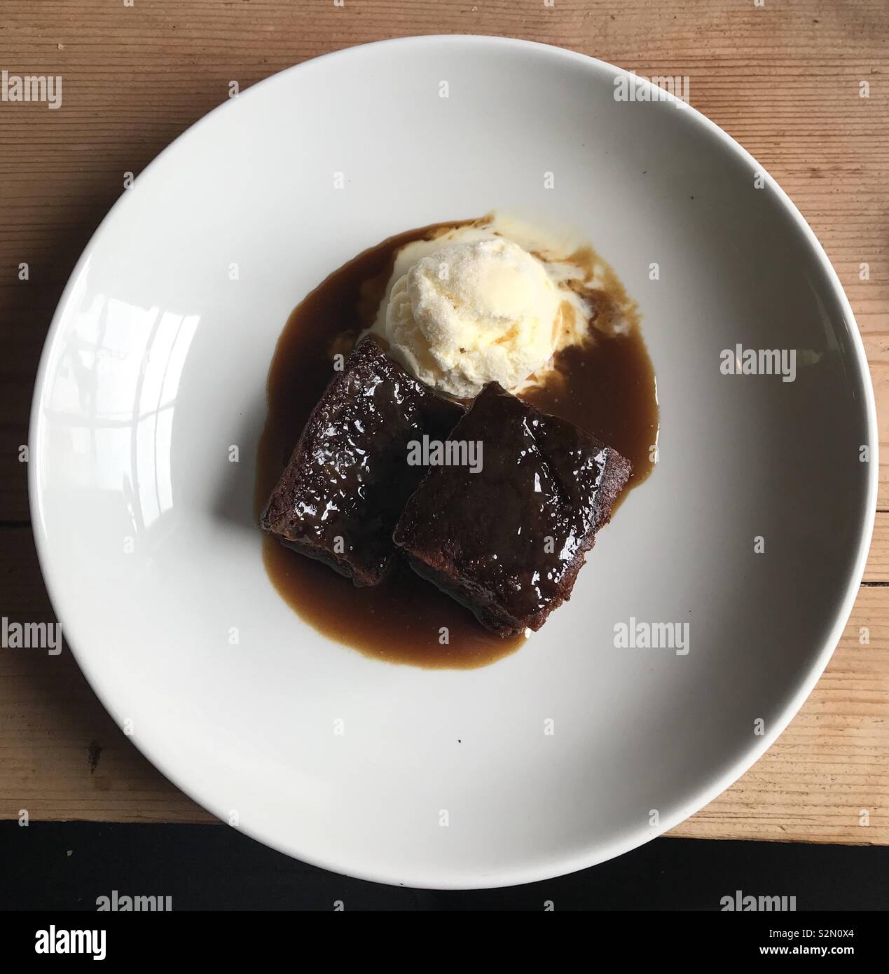 Sticky toffee pudding con gelato alla vaniglia a Diablo, Carmarthen, Galles. - Immagine stock catturata con smartphone