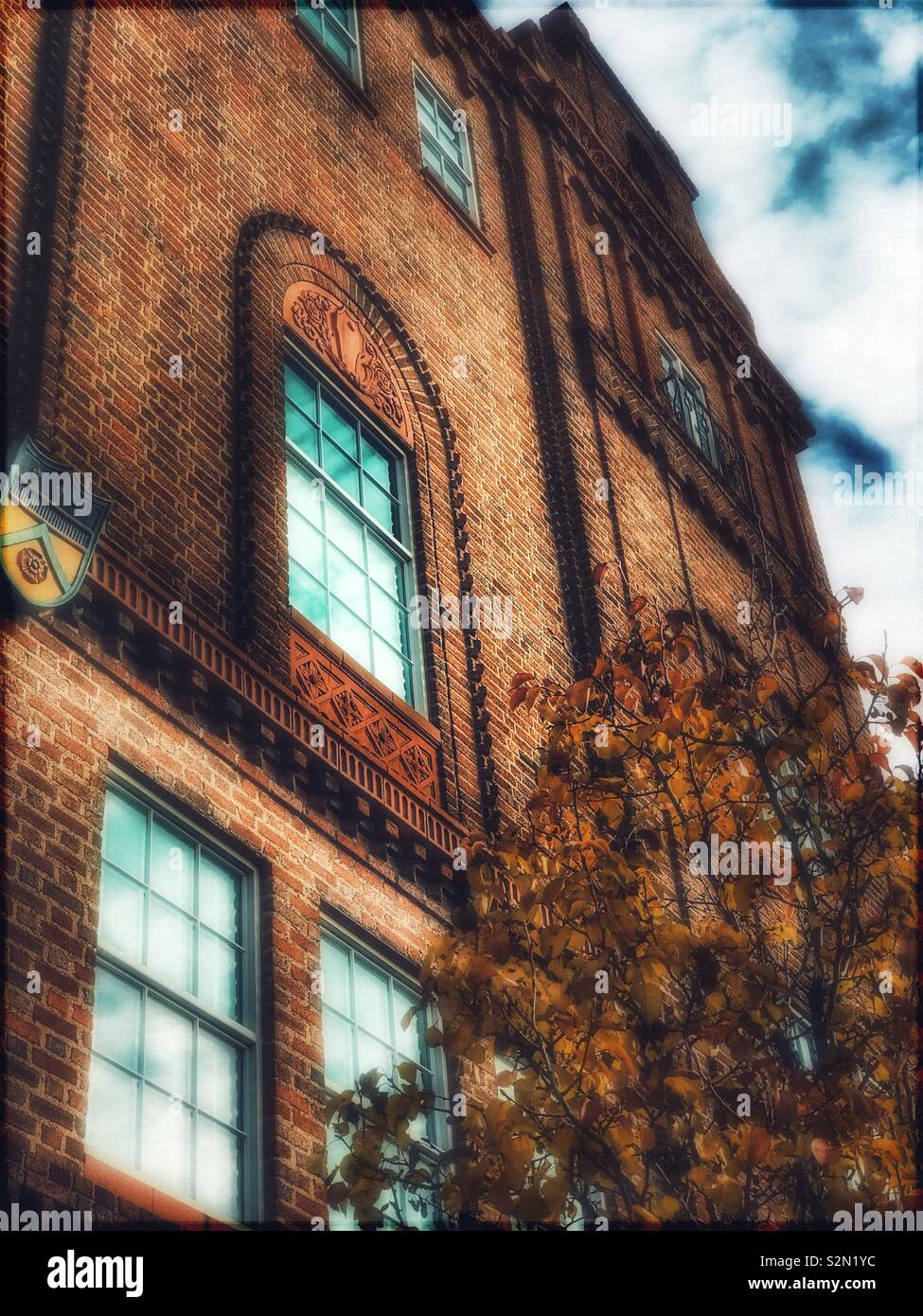 Ornati edificio in mattoni e albero in autunno - Immagine stock catturata con smartphone