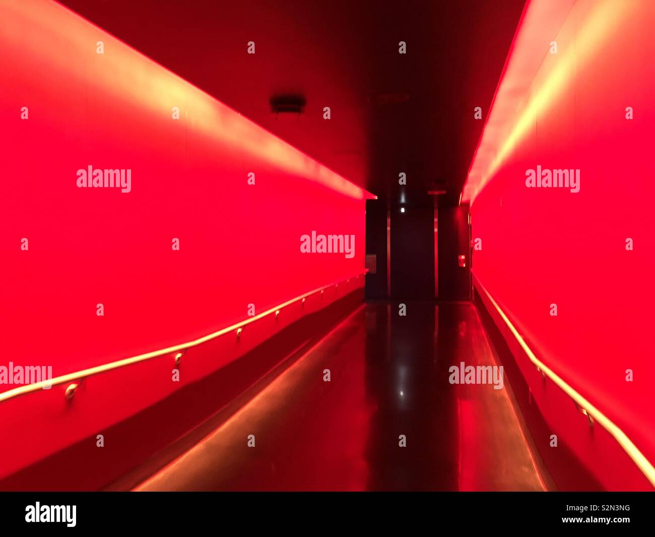 Rosso brillante illuminazione in un corridoio vuoto Foto Stock