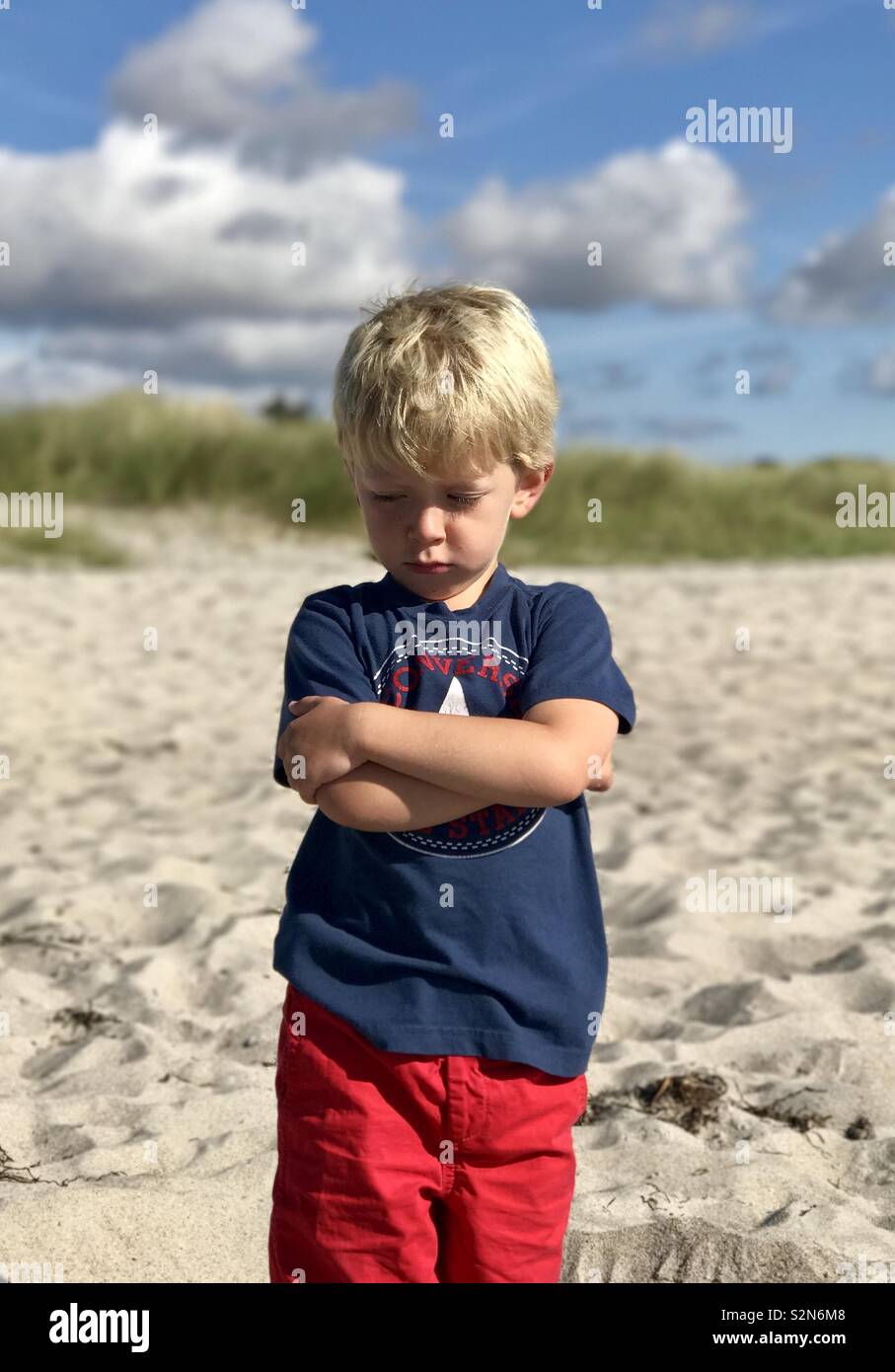 Burbero ragazzo sulla spiaggia Foto Stock