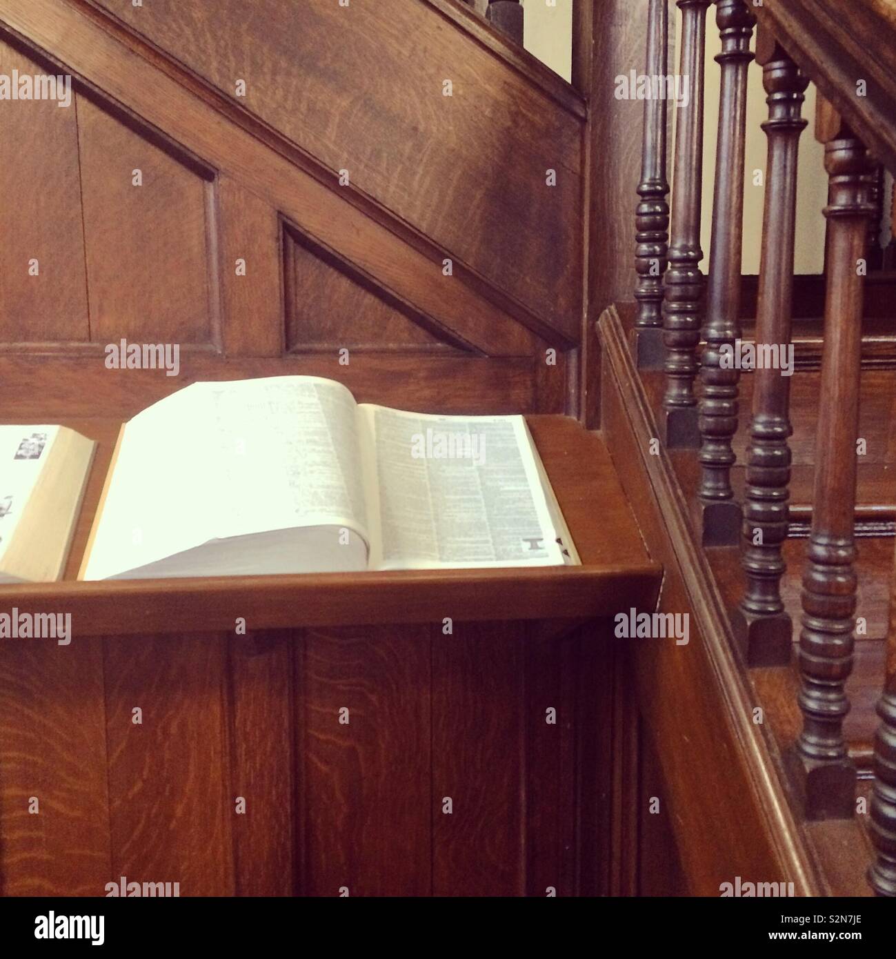 Aprire il libro di riferimento nel mezzo di legno in una libreria Foto Stock
