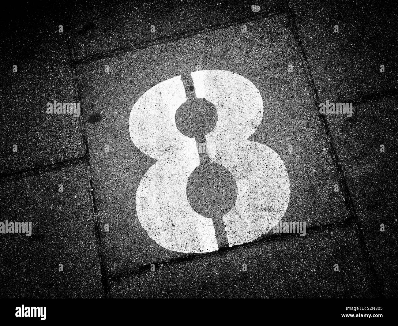 Il numero otto è dipinta su un blocco in calcestruzzo su un marciapiede. 8. Alcune culture pensa che il numero otto è un numero importante. N. persone. Spazio per la copia. Foto - © COLIN HOSKINS. Foto Stock