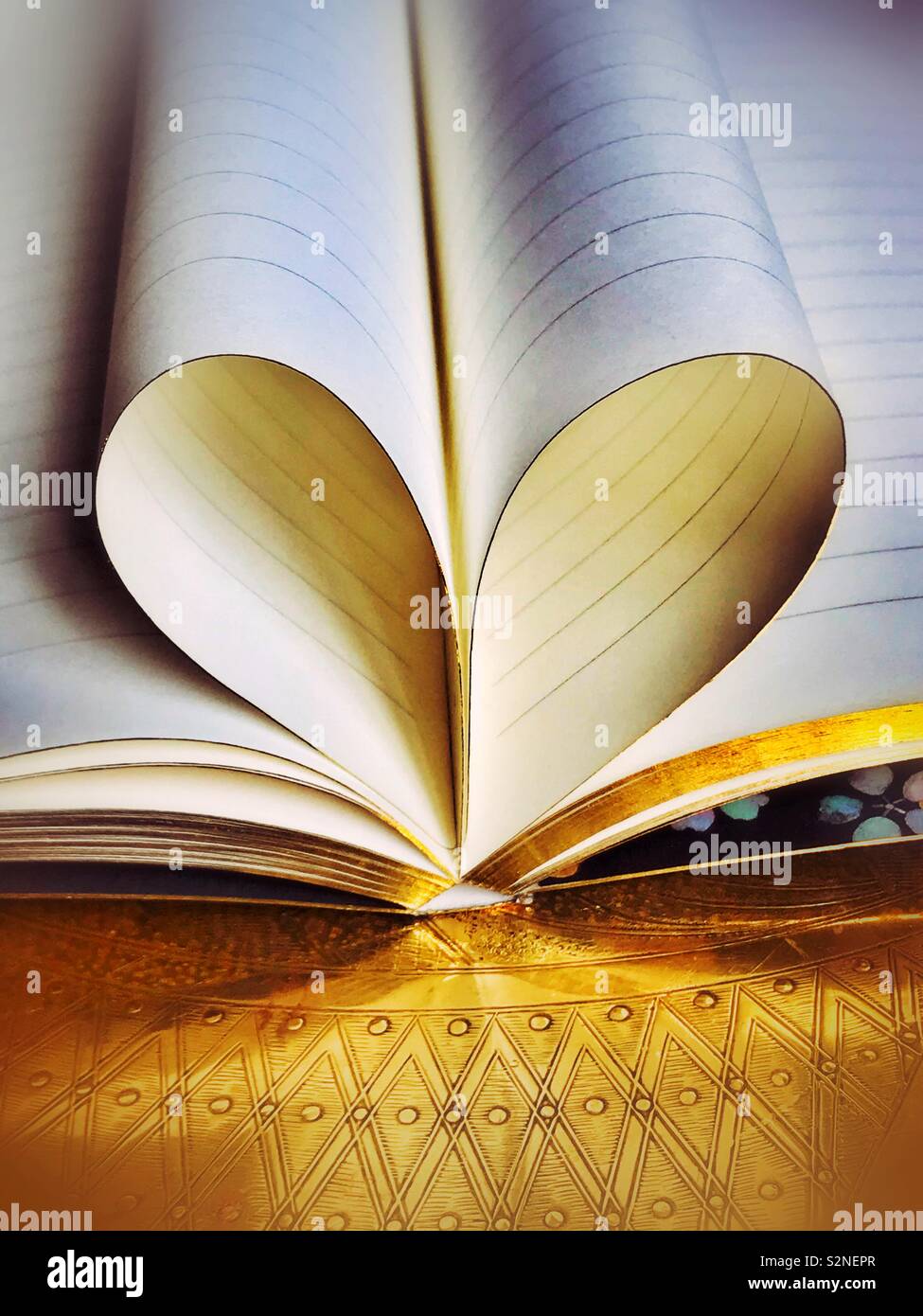 La scrittura di un libro con pagine rivolta alla creazione di un amore cuore Foto Stock