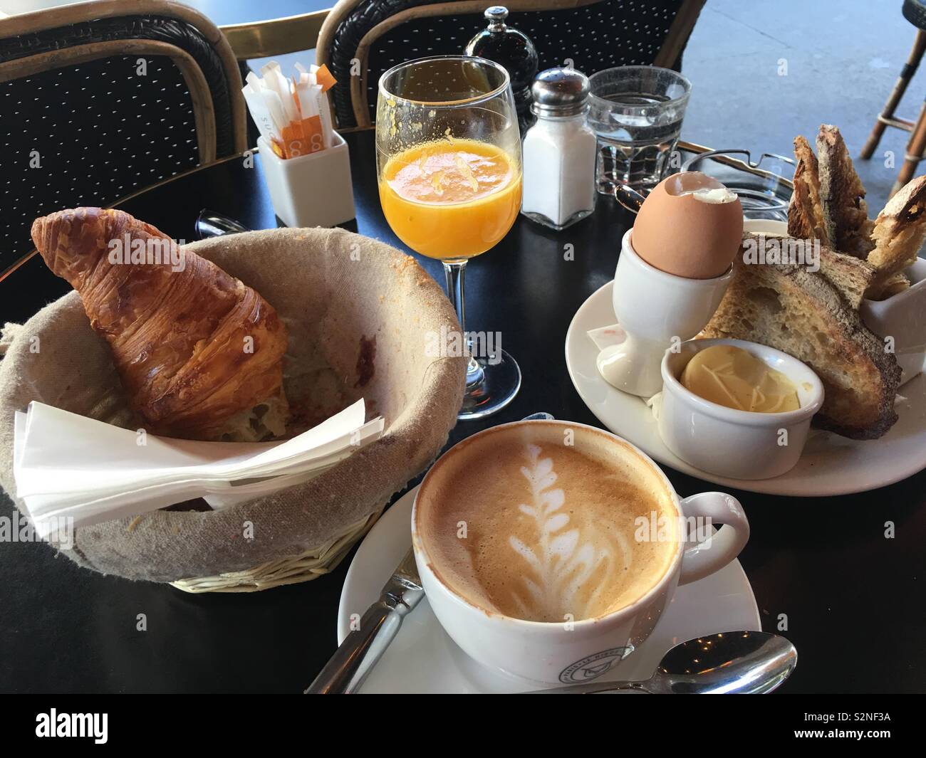 Un Cafe' Parigino Prima colazione in aprile con spremuta fresca di succo  d'arancia, croissant e un organico di uova sode Foto stock - Alamy