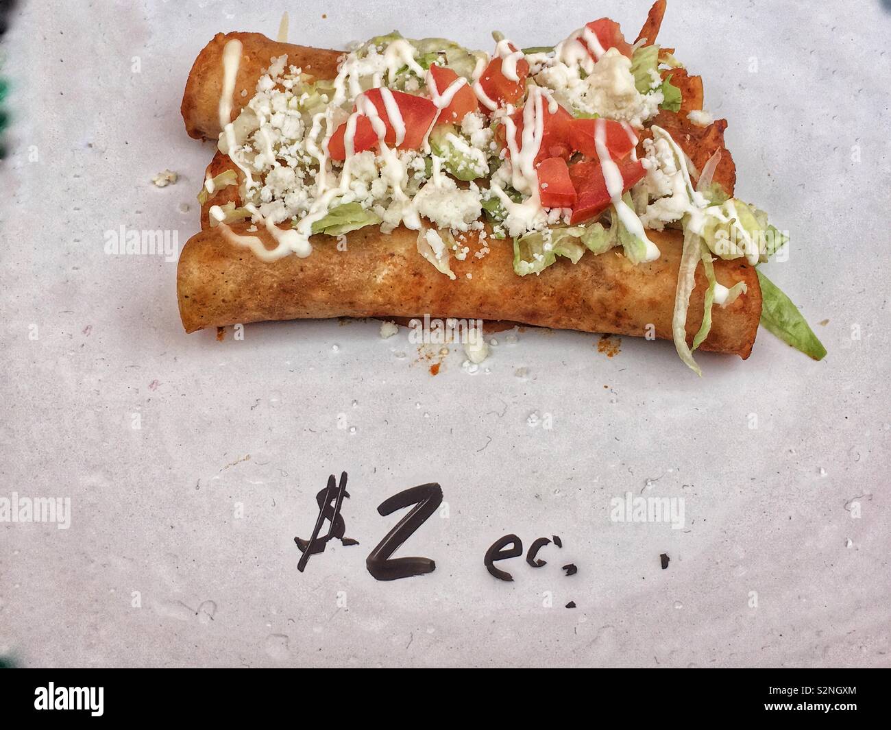 Due chimichangas caricato con pomodoro, formaggio e lattuga per 2 dollari come la deliziosa cucina di strada. - Immagine stock catturata con smartphone