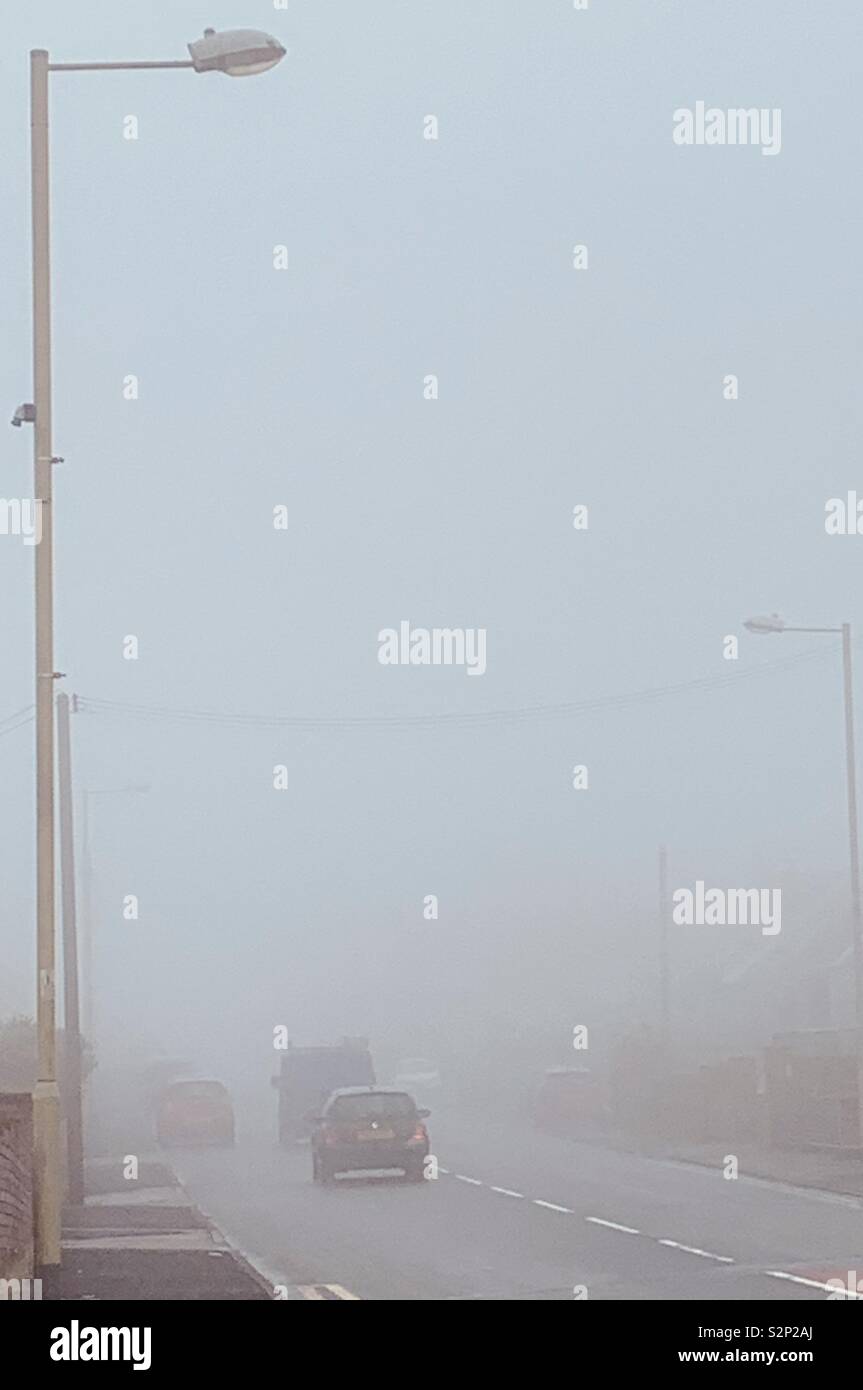 Le automobili in salita su in nebbioso giorno Foto Stock