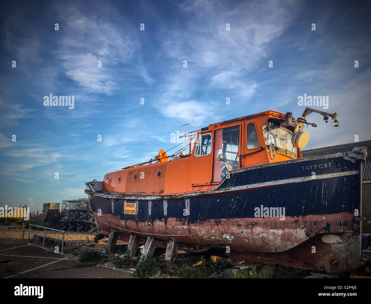 Ritirato RNLI scialuppa di salvataggio in una spiaggia parco auto Foto Stock