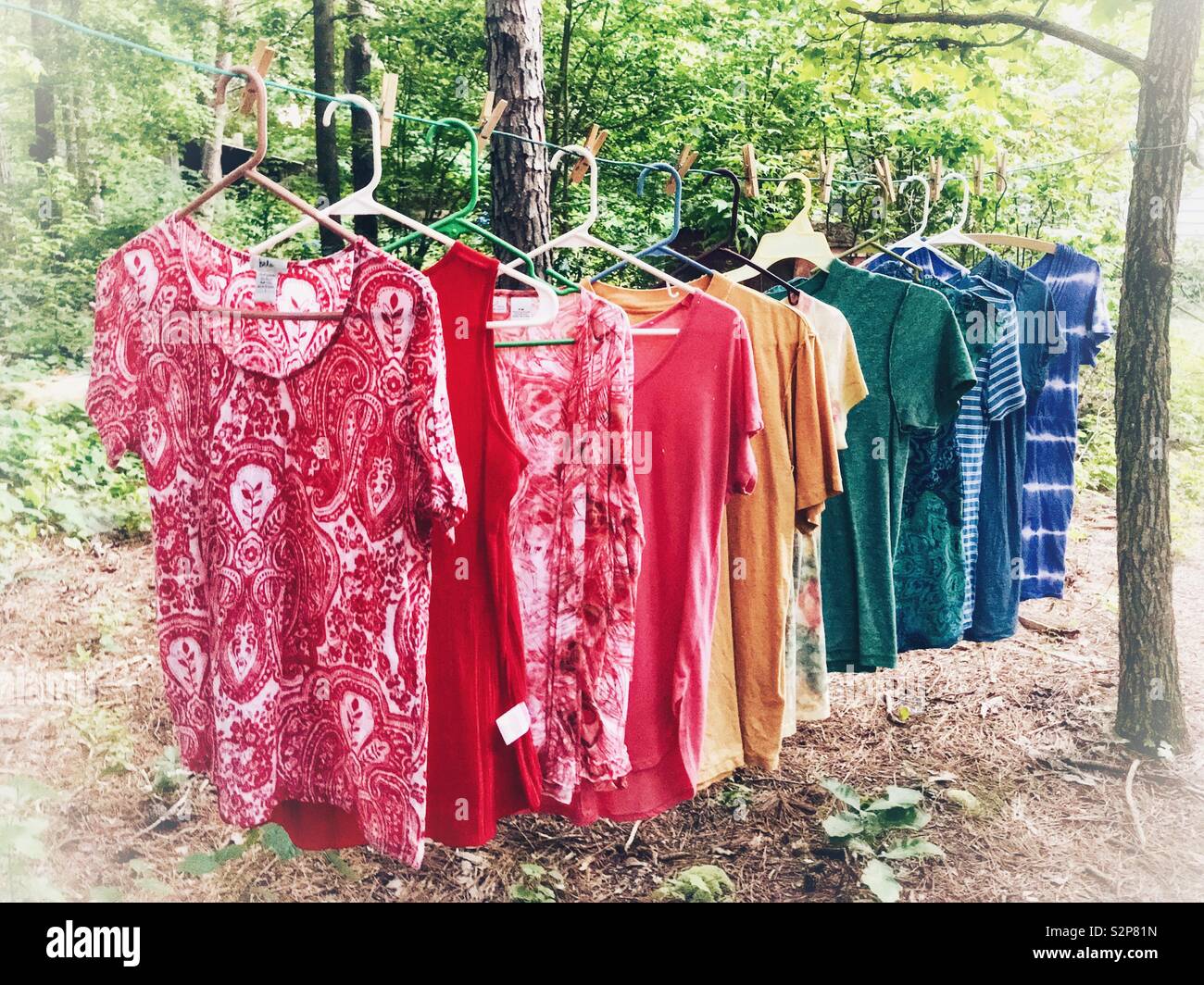 Tops appeso su uno stendibiancheria in un arcobaleno la formazione di colore Foto Stock
