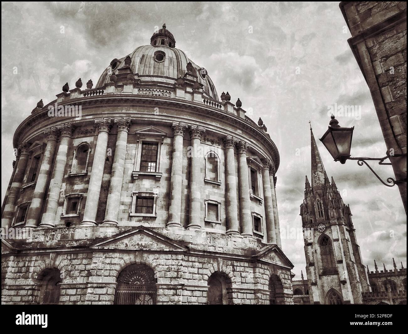 La Radcliffe Camera edificio a Oxford, Inghilterra. Non è una vera e propria fotocamera - ma una libreria utilizzata dagli studenti dell'Università di Oxford. Il tall spired chiesa è l'università chiesa di Santa Maria Vergine. © Foto Stock