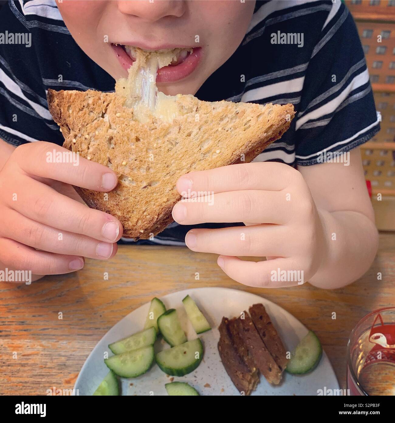 Ragazzo di mangiare un formaggio Toastie Foto Stock