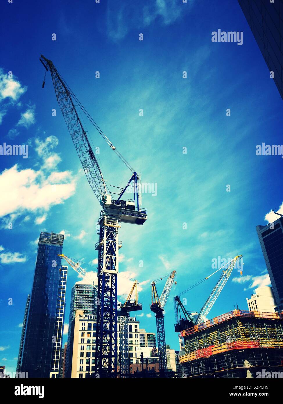 Gru edili in un alto edificio sito in costruzione nei pressi di cantieri Hudson, New York, Stati Uniti d'America - Immagine stock catturata con smartphone