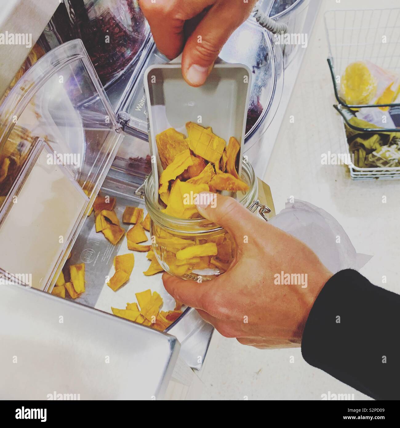 Shopper ricarica di un vasetto Kilner con pacchetto gratuito di mango essiccato Foto Stock