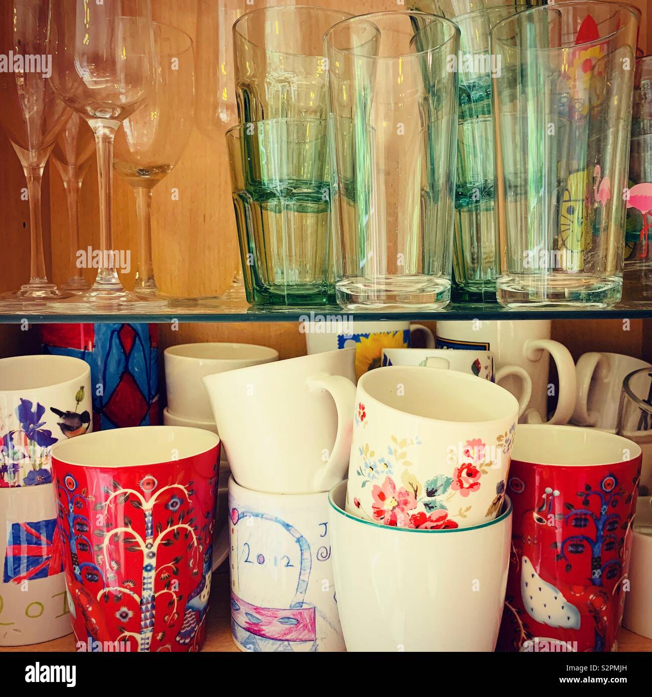 Tazze e bicchieri all'interno di un mobile da cucina Foto Stock