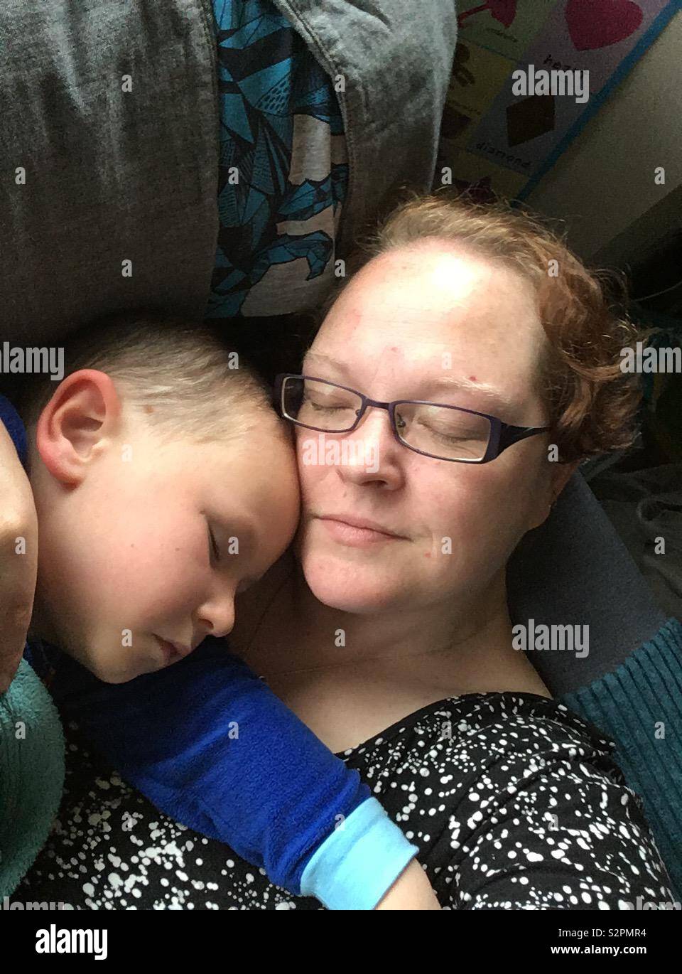 La madre e il figlio di 4 anni slumber sul divano Foto Stock